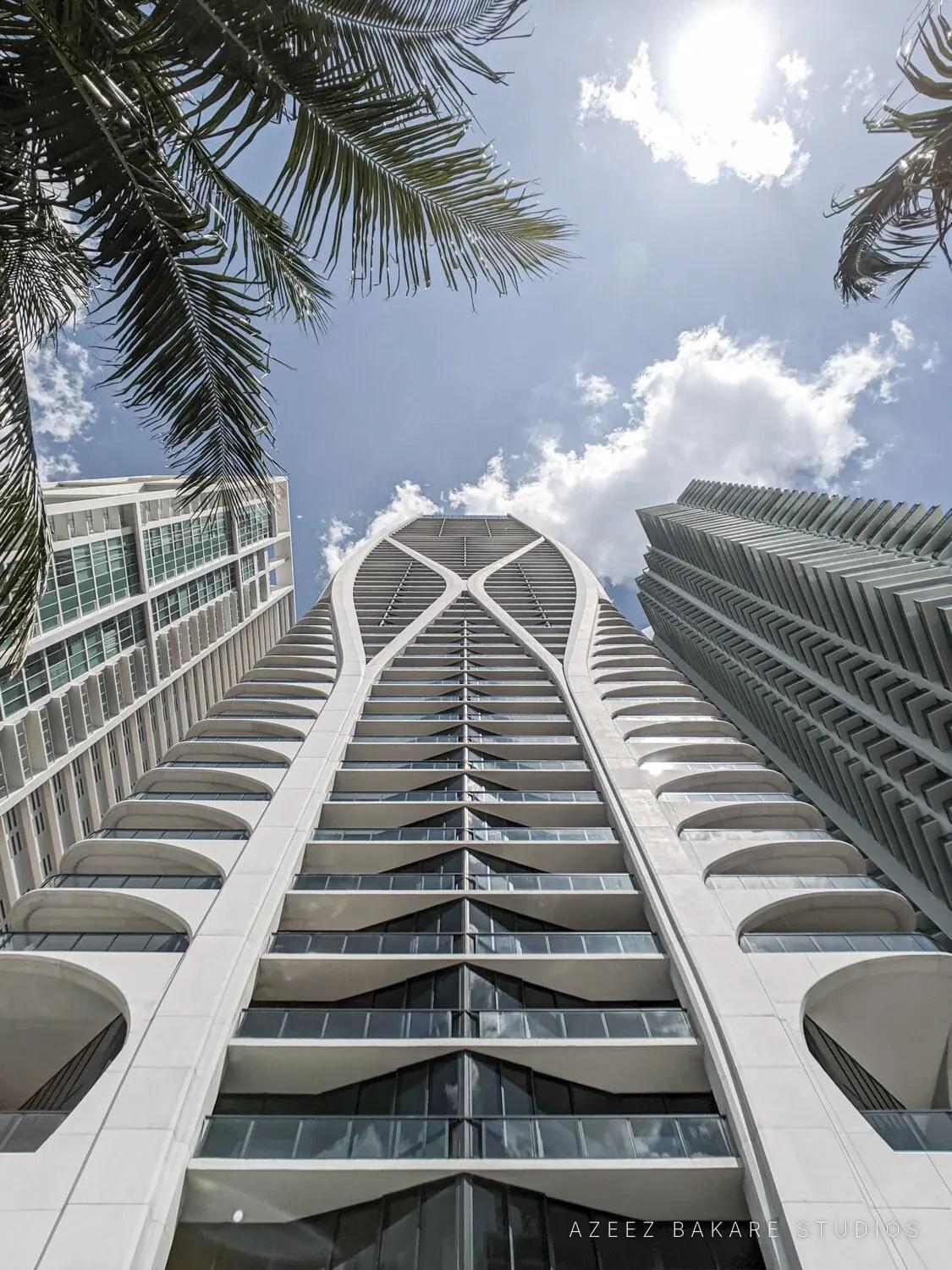 Looking up a Miami tower with arched white balconies, architectural photograph by Azeez Bakare Studios
